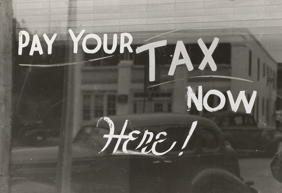 Window Sign Says Pay Your Tax Now Here