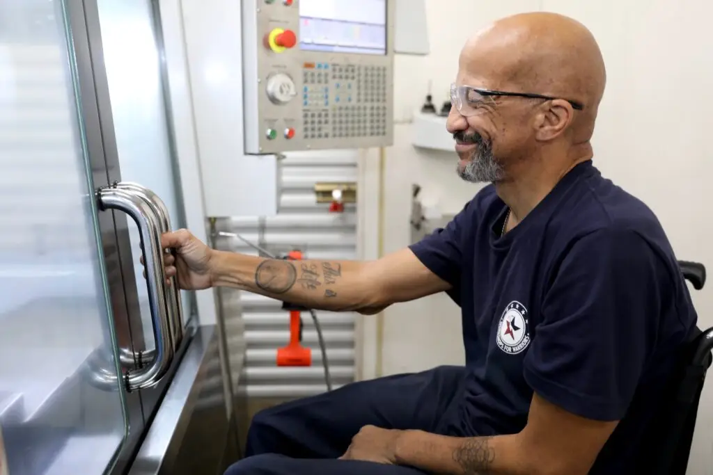 Joe working at machine at Workshops For Warriors