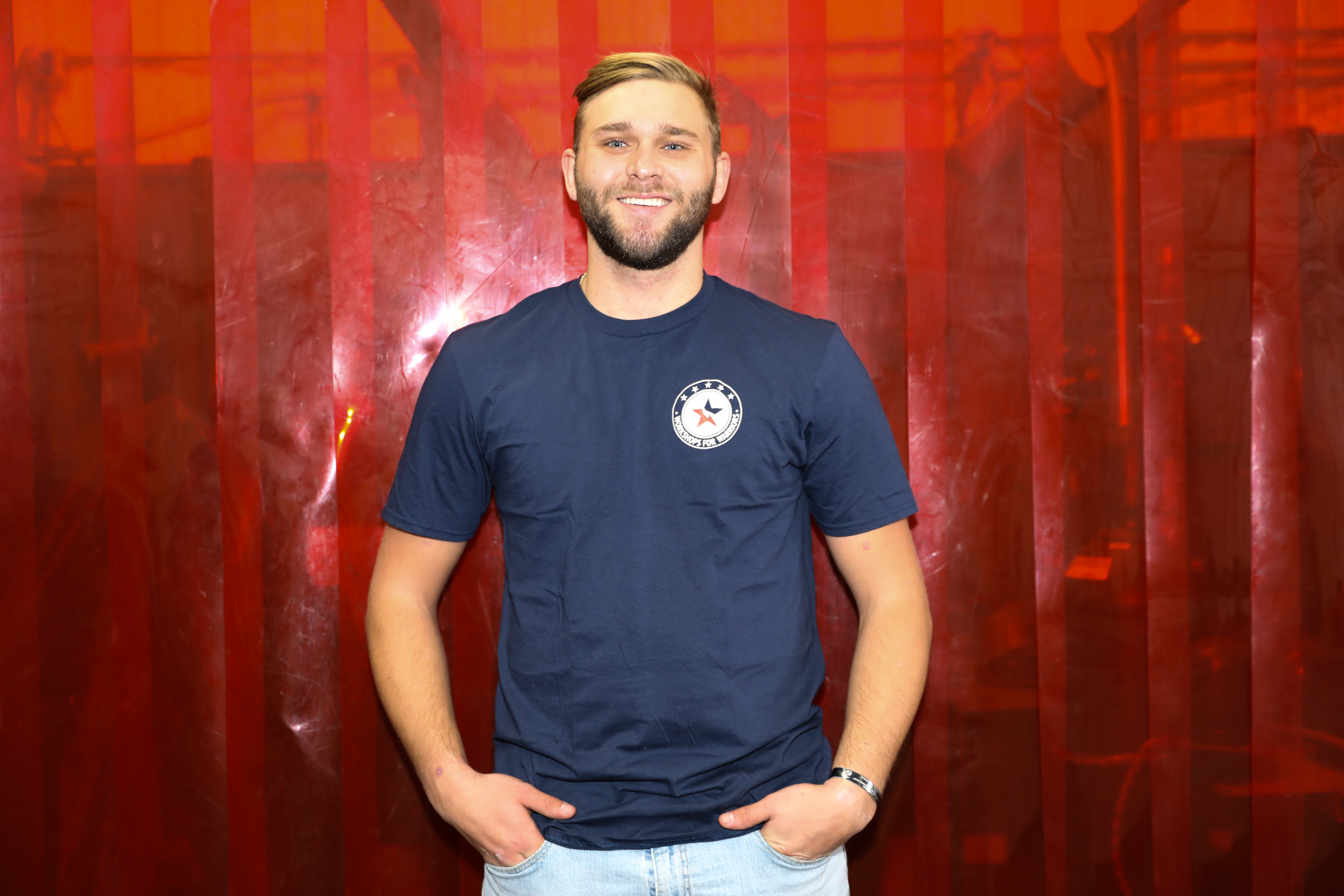 Marine Corps veteran in front of red welding curtains